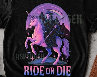 May include: Black unisex t-shirt featuring a graphic of a cloaked figure riding a pink unicorn with a scythe. The design is set against a purple and pink background with the words "RIDE OR DIE" in a gradient font.