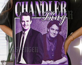May include: Black t-shirt featuring a purple graphic of Chandler Bing from the TV show Friends. The graphic includes two images of the actor and the text "CHANDLER BING" in a stylized font. The shirt is a vintage style.