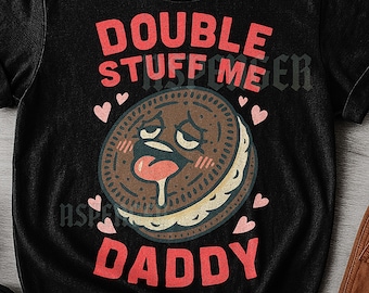 Może przedstawiać: Czarny t-shirt unisex z grafiką z kreskówkowym ciasteczkiem z wystającym językiem. Tekst na koszulce brzmi "DOUBLE STUFF ME DADDY" w kolorze czerwonym. Różowe serca otaczają ciastko.