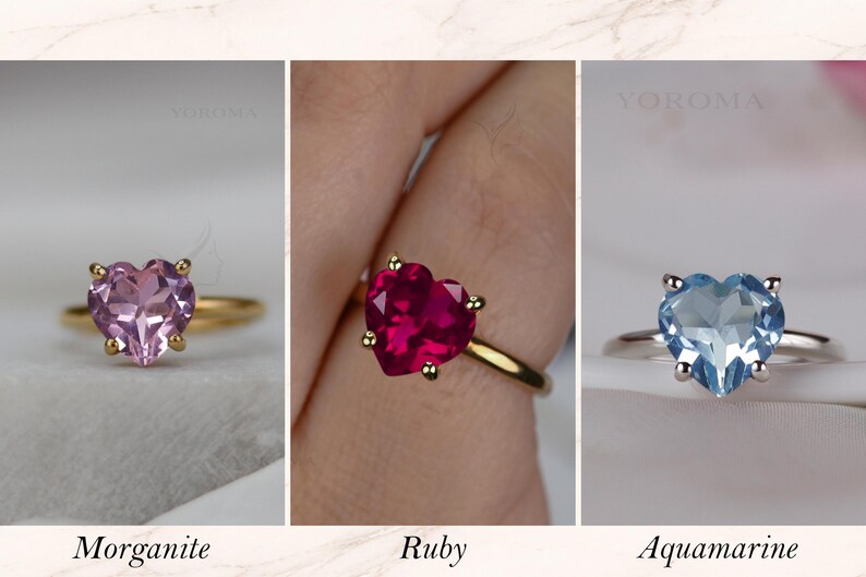 Puede incluir: Tres anillos con gemas en forma de coraz&oacute;n marcados como YOROMA. El primero es una morganita rosa en banda dorada, el segundo un rub&iacute; rojo intenso en banda dorada y el tercero una aguamarina azul claro en banda plateada, con cuatro garras.