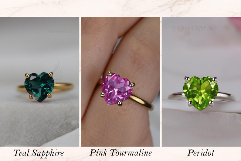 Puede incluir: Tres anillos con piedras preciosas talladas en forma de coraz&oacute;n. El primero es un zafiro azul verdoso en banda dorada, el segundo una turmalina rosa en banda dorada y el tercero un peridoto verde brillante en banda plateada, con sus nombres.