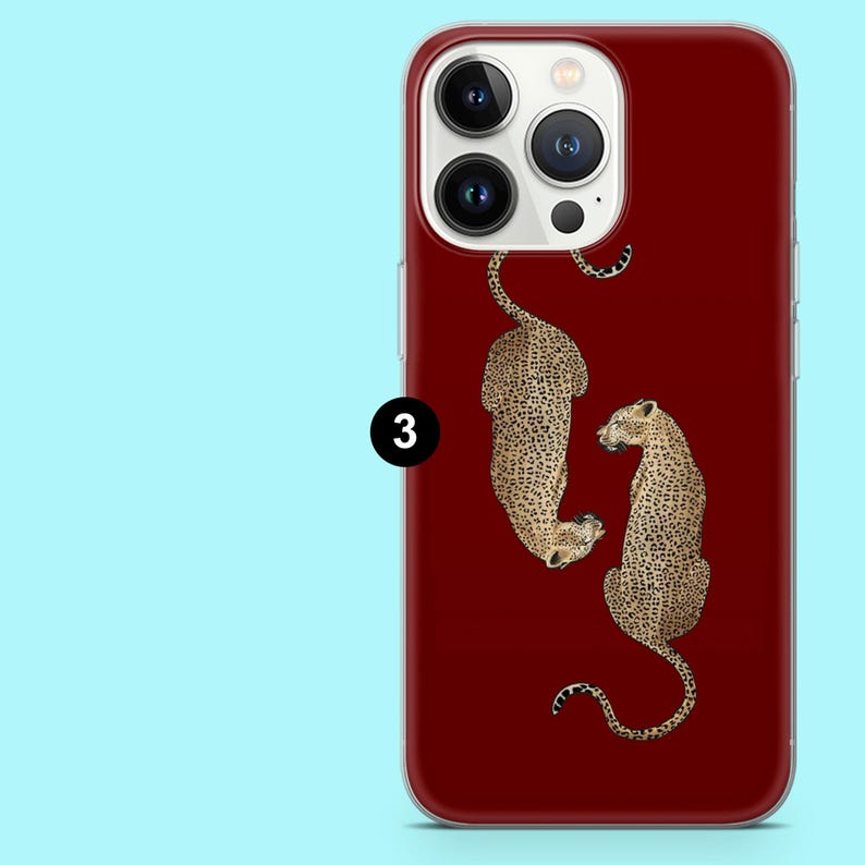 Puede incluir: Funda de tel&eacute;fono burdeos con un dise&ntilde;o de dos leopardos con manchas marrones y negras. Los leopardos se colocan sobre un fondo burdeos liso. La funda tiene un borde transparente.