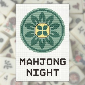 May include: A cross-stitch design featuring a green floral emblem with a yellow center, set against a white background. The words "MAHJONG NIGHT" are stitched in black block letters below the emblem. The background is blurred with Mahjong tiles.