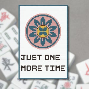 May include: A cross-stitch design featuring a pink and teal floral pattern with a yellow center, framed in a teal border. The text "JUST ONE MORE TIME" is below the design. Mahjong tiles are in the background.