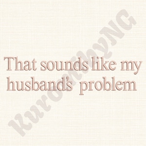 May include: A light beige background with the embroidered text "That sounds like my husband's problem" in a light brown color. The text is centered and in a serif font.