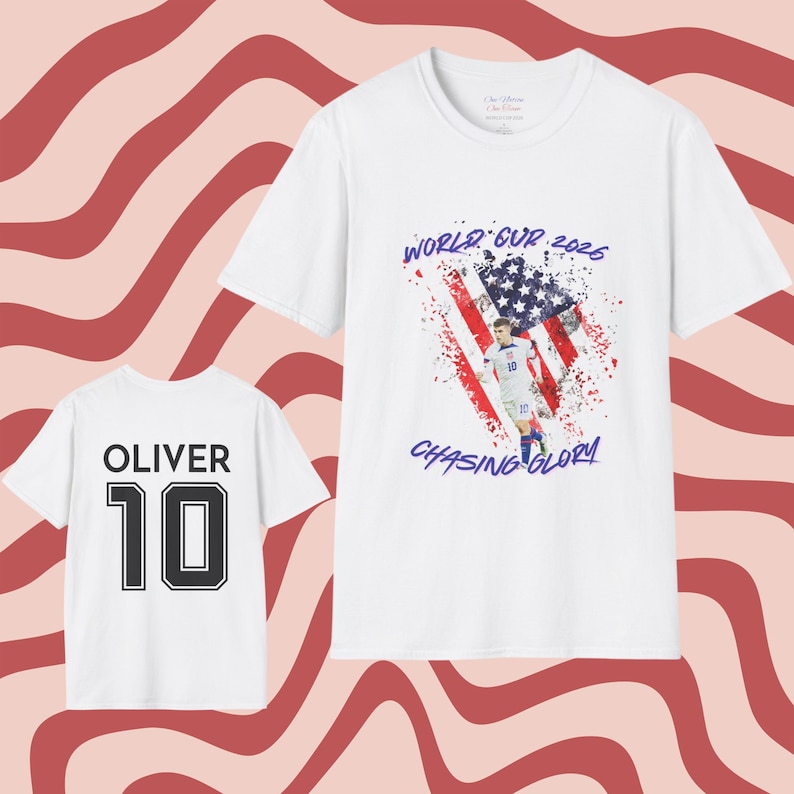 May include: Two white t-shirts. One features the name "OLIVER" above the number "10" in black. The other shirt has a graphic of a soccer player in front of an American flag with the text "WORLD CUP 2026" and "CHASING GLORY".