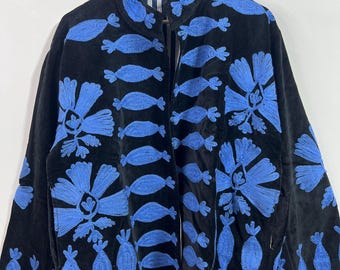 May include: Black jacket with blue floral embroidery. The jacket features a high collar and a full-length zipper. The lining is a striped pattern of white and blue. The jacket is hanging on a wooden hanger.