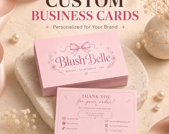 May include: A stack of rectangular light pink business cards featuring a bow graphic and the text Blush Belle Beauty Confidence You, alongside a matching thank you card with social media icons and the text Thank you for your order.