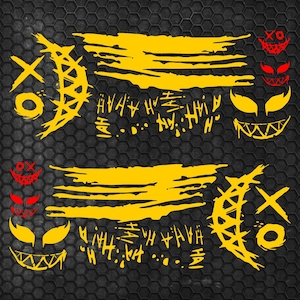 May include: A set of yellow and red vinyl decals featuring two crescent moon shapes with X and O markings, two horizontal brushstroke patterns, repeated HAHA text, and several stylized grinning faces with sharp teeth and pointed eyes.