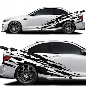 May include: White sports car with black abstract splash design decals on the side panels. The car has black rims, tinted windows, and a rear spoiler. The image shows two views of the car.