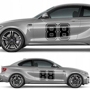 Peut inclure: Deux voitures argentées avec des autocollants noirs et blancs du numéro 88 sur le côté. Les autocollants sont dans un style de lettres en bloc. Les voitures ont des jantes et des pneus noirs.