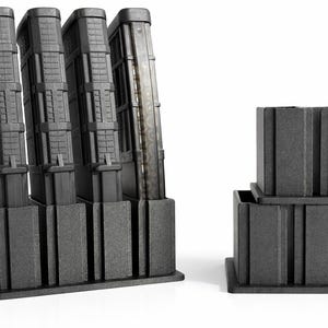 May include: A set of four black magazine holders with a textured surface, angled slightly to the left. A smaller set of two matching holders is to the right. The holders are designed to store magazines.