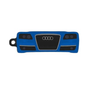 May include: A blue car-shaped keychain featuring a black grille with the Audi logo and black headlights. The keychain has a small loop on the left side.