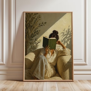 Pode incluir: Uma impressão de arte emoldurada retrata uma pessoa lendo um livro verde em uma poltrona creme. A pessoa está vestindo roupas creme. A luz solar e as sombras criam uma atmosfera acolhedora e convidativa.