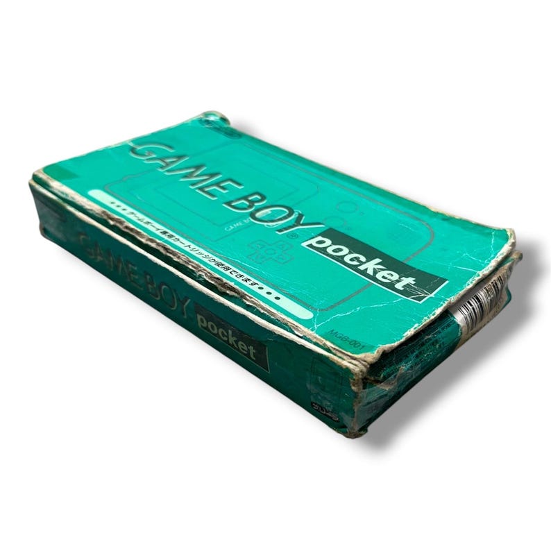 May include: A teal cardboard retail box for a Game Boy Pocket handheld gaming console. The box features the text GAME BOY pocket in white and black, with Japanese characters printed on the top surface and the model number MGB-001 visible.