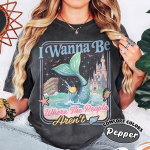 May include: A white ceramic mug with a black handle and the text "But First, Coffee" in a black, handwritten-style font. The mug is on a white surface.