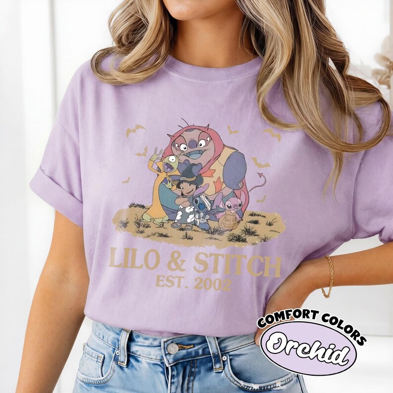 K&ouml;nnte beinhalten: Orchideenfarbenes T-Shirt mit einer Grafik von Charakteren aus Lilo & Stitch, mit dem Text "Lilo & Stitch Est. 2002." Das Shirt ist von der Marke Comfort Colors.