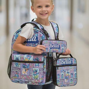 May include: A light blue and purple backpack, pencil case, and lunch bag set with a cartoon character design. Each item has the name "Bella" printed on it. The backpack has multiple compartments and mesh side pockets.