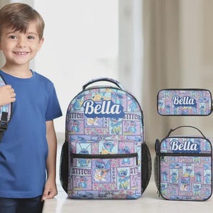 May include: A child stands with a backpack, lunch bag, and pencil case set. The set features a repeating cartoon character pattern in blue, purple, and pink. The name "Bella" is printed on each item. The backpack is designed for school use.