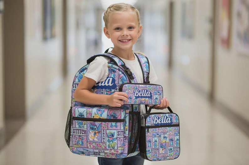 May include: A light blue and purple backpack, pencil case, and lunch bag set with a cartoon character design. Each item has the name "Bella" printed on it. The backpack has multiple compartments and mesh side pockets.