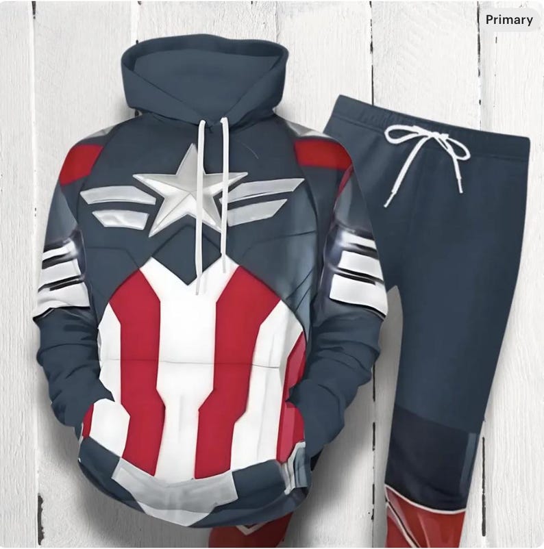 Op de afbeelding: Een marineblauwe hoodie en bijpassende joggingbroek set. De hoodie heeft een Captain America-ontwerp met een witte ster, rood-witte strepen en zilveren accenten. De joggingbroek heeft een taille met trekkoord en een rood accent bij de enkel.