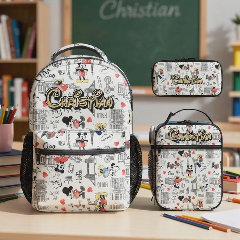 May include: A white backpack, lunch bag, and pencil case set featuring a repeating pattern of Mickey Mouse illustrations, hearts, and text. The name "Christian" is written in gold script on each item. The backpack has black mesh side pockets.