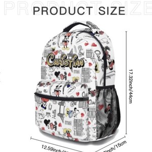 May include: White backpack with a repeating pattern of cartoon characters, hearts, and text. The backpack features the name "Christian" in gold lettering. It measures 17.32 inches (44 cm) high, 12.59 inches (32 cm) wide, and 5.9 inches (15 cm) deep.