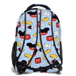 May include: A light blue backpack featuring a repeating pattern of Mickey Mouse's face, gloves, and shoes in red, black, yellow, and white. The backpack has black straps, a handle, and side mesh pockets.