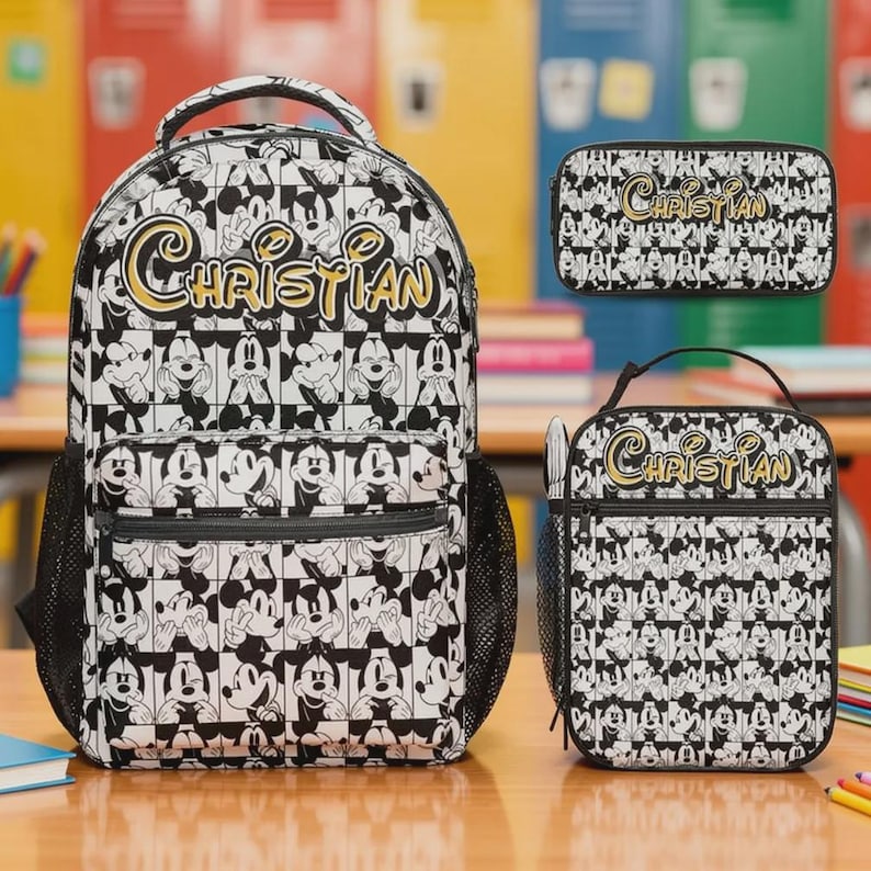 May include: A black and white backpack, pencil case, and lunch bag set. The set features a repeating pattern of Mickey Mouse illustrations. The name "Christian" is written in gold script across each item. The backpack has a mesh side pocket.