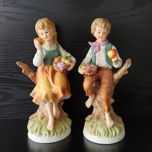 Figurines vintage en porcelaine de style Capodimonte - Garçon et fille avec des paniers de fruits - Paire de marques italiennes