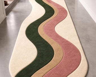 May include: A long, oval-shaped runner rug featuring a wavy, multi-coloured pattern. The design consists of flowing, curved bands in cream, dark forest green, tan, and dusty rose pink, creating a continuous, undulating visual effect across the surface.