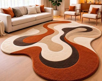 May include: An irregularly shaped area rug featuring a flowing, abstract pattern of wavy lines in shades of burnt orange, dark brown, beige, and cream. The rug has a thick, textured pile and is placed on a light-coloured wooden floor.