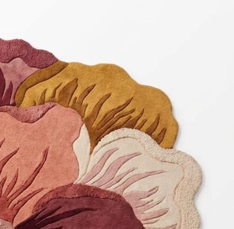 May include: A tufted area rug featuring a large, stylized floral pattern with organic, curved edges. The design incorporates a warm color palette of deep burgundy, muted rose, soft cream, and golden mustard yellow with textured pile details.