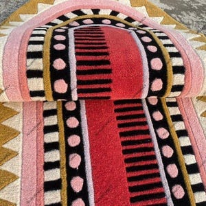 May include: A white ceramic mug with a black handle and the text "But First, Coffee" in a black, handwritten-style font. The mug is on a white surface.