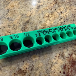 Könnte beinhalten: Ein hellgrüner Pittsburgh Hex Socket SAE Halter mit mehreren kreisförmigen Öffnungen für Steckschlüssel. Die Größen sind in Zoll angegeben, von 5/32 bis 5/8. Der Werkzeughalter dient zum Ordnen und Aufbewahren von Steckschlüsseln.