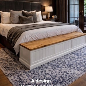 May include: The Harley Storage Bench, a white and wood-toned storage bench at the foot of a bed. The bench has a wooden top and white paneled sides. The bed has a gray headboard and is covered with white bedding and gray pillows.