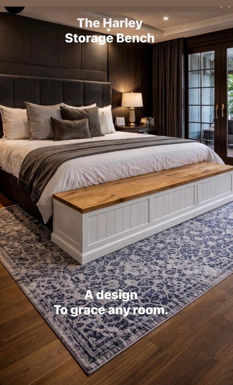 May include: The Harley Storage Bench, a white and wood-toned storage bench at the foot of a bed. The bench has a wooden top and white paneled sides. The bed has a gray headboard and is covered with white bedding and gray pillows.