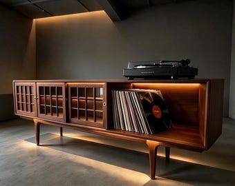 May include: A long, low-profile wooden media console featuring three sliding cabinet doors with a grid-patterned glass design. The unit includes an open storage section filled with vinyl records and a black turntable placed on the top surface.