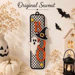 May include: A vertical black lattice-style wall hanging featuring the embroidered orange text BOO, a white ghost, a black witch hat with a purple band and yellow buckle, and two small yellow stars. The text Original Sewout is printed above.