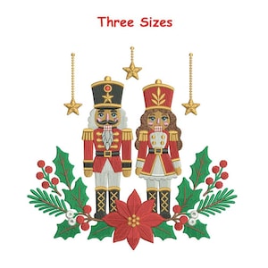 Puede incluir: Un diseño de bordado con dos figuras de cascanueces en uniformes rojos y dorados, rodeados de hojas de acebo verdes, bayas rojas y una flor de pascua roja central. Tres estrellas doradas cuelgan de cadenas arriba. El texto Three Sizes está arriba.