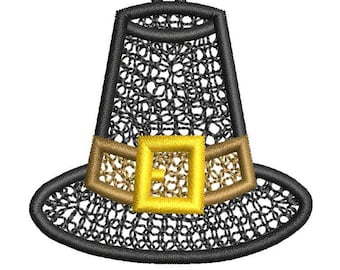 Può includere: Un ricamo a forma di cappello da pellegrino nero con un motivo a rete testurizzato sulla corona e sulla tesa. Il cappello presenta una fascia color marrone chiaro e una fibbia quadrata giallo brillante al centro, con un piccolo occhiello in alto.