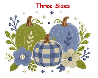 Può includere: Un disegno per ricamo con tre zucche in verde, blu e un motivo a quadri blu e bianco, circondate da foglie verdi, bacche blu e due fiori. Il testo "Three Sizes" è stampato in rosso nella parte superiore dell'immagine.