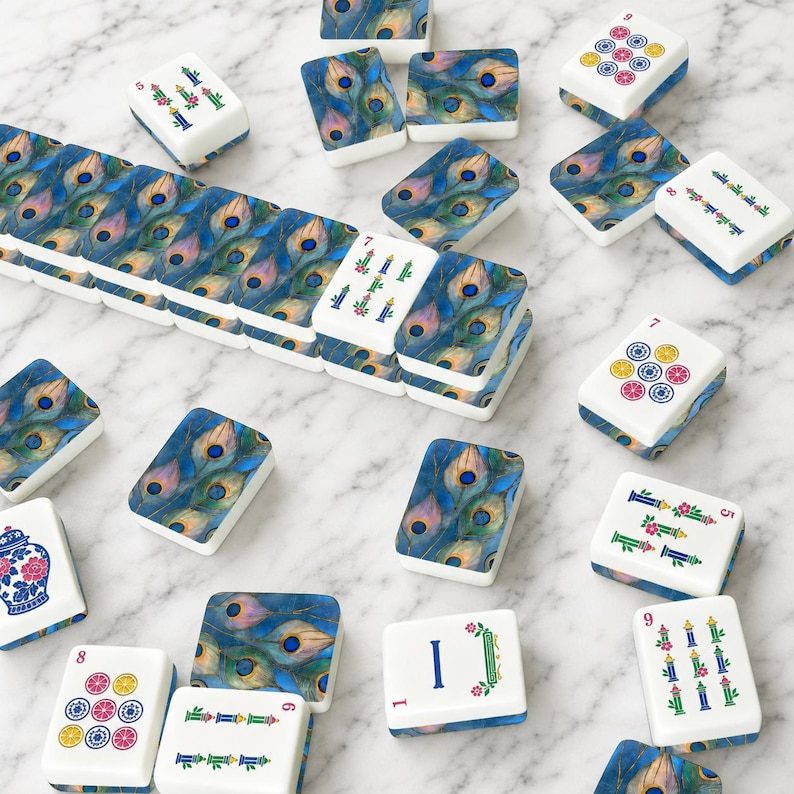 May include: A set of rectangular mahjong tiles featuring a vibrant peacock feather pattern in shades of blue, green, and gold. Some tiles display numerical values and colorful floral motifs, while others show a blue and white porcelain vase design.