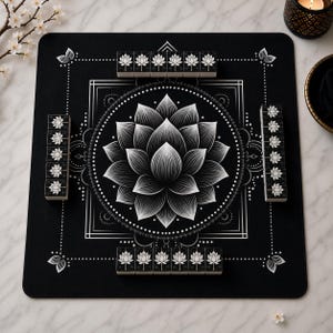 May include: A square black mahjong mat featuring a large white lotus flower graphic in the center, surrounded by geometric lines and dots. Four rows of matching black and white lotus-patterned mahjong tiles are arranged along the edges.