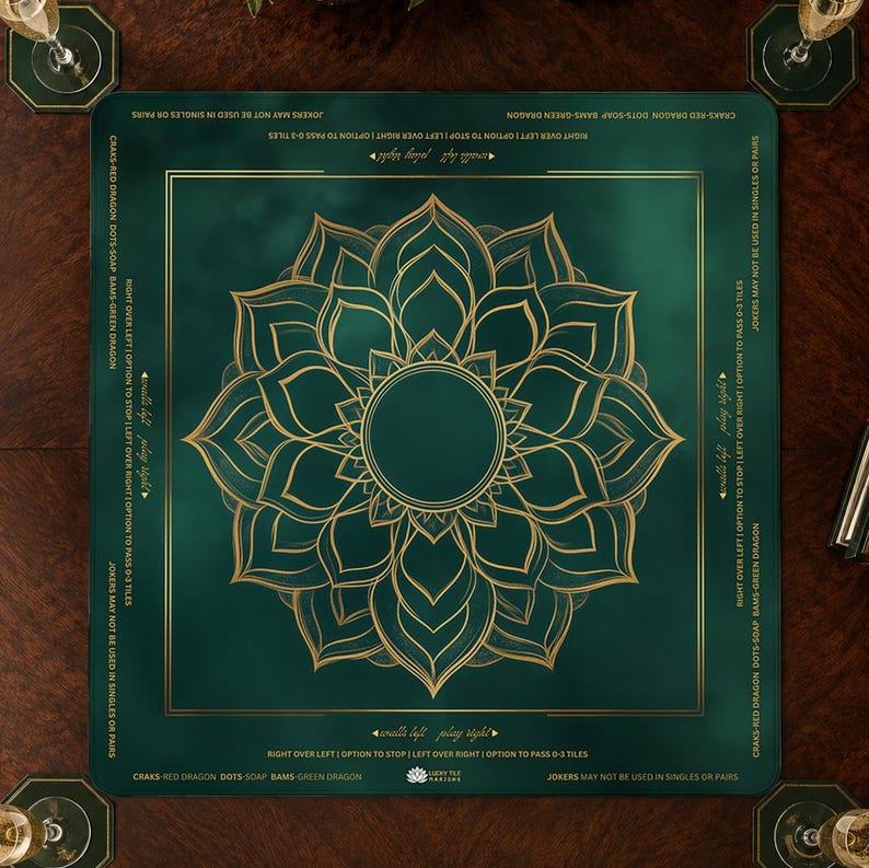 May include: A green game mat with a gold floral design in the center. The mat has text around the edges and is surrounded by matching coasters. The mat is designed for a game.