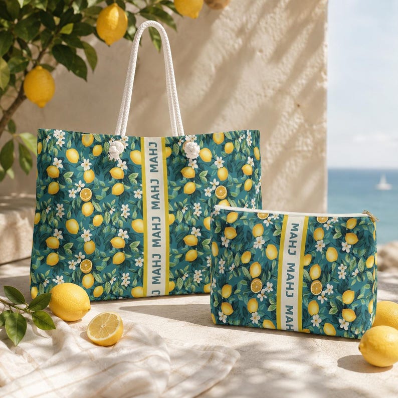 May include: A tote bag and a matching zippered pouch featuring a dark teal background with a repeating pattern of yellow lemons, green leaves, and white blossoms. Both items have a vertical yellow stripe with the text MAHJ printed repeatedly.