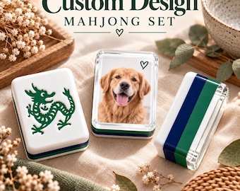 May include: Three rectangular mahjong tiles with a custom design. One tile features a green dragon, one displays a golden retriever portrait with a small heart, and one shows a blue and green striped pattern. The text Custom Design Mahjong Set is visible.