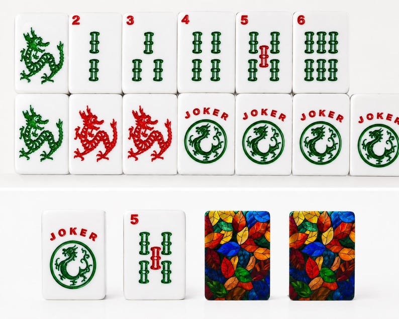 May include: A collection of white rectangular Mahjong tiles featuring green and red dragon illustrations, numbered bamboo suits, and tiles labeled JOKER with a circular dragon emblem. Two tiles display a colorful stained-glass leaf pattern.