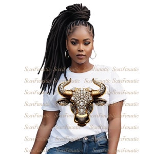 May include: A white t-shirt with a gold and diamond encrusted bull head graphic. The bull has a gold nose ring and horns.