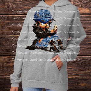May include: A gray hoodie featuring a graphic of a cartoon character wearing a blue Aries cap, ripped jeans, and black boots, holding a phone. The hoodie has a front pocket and a drawstring hood.